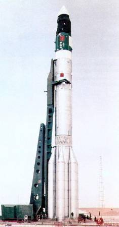 An image of the Proton rocket that launched the Salyut 1 into orbit. It is fully white with a green docking column beside it.